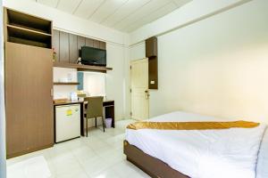 Un dormitorio con una cama y un escritorio y una cocina. en Riski Residence Bangkok-noi - Wasit Apartment, en Bangkok