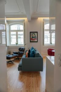 eine Person, die auf einer Couch im Wohnzimmer sitzt in der Unterkunft Lisbon Center Rua Augusta Modern Art Apartment in Lissabon