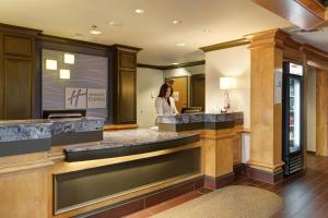 a woman standing behind a counter in a hotel lobby at Holiday Inn Express Hotel & Suites Warwick-Providence Airport, an IHG Hotel in Warwick