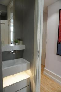un bagno con lavandino e specchio di Lisbon Center Rua Augusta Modern Art Apartment a Lisbona Altre 32 foto