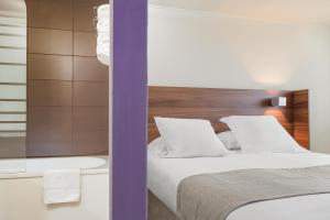 a bedroom with a bed and a bath tub next to at Terre de Provence Hôtel & Spa in Le Pontet +34 photos