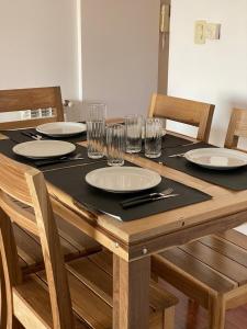 una mesa de madera con platos y vasos. en Luxury Appart en Salta