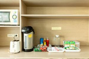 una cafetera sentada en un estante junto a un microondas en Riski Residence Bangkok-noi - Wasit Apartment, en Bangkok