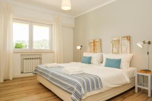 a bedroom with a large white bed with blue pillows at Lisbon Country Villa in Oeiras +23 photos