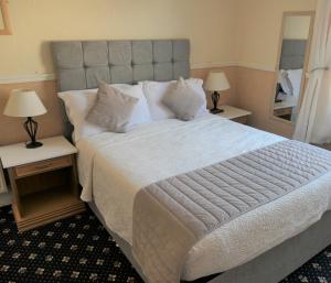 1 dormitorio con 1 cama grande y 2 mesitas de noche en The Cumberland, en Llandudno