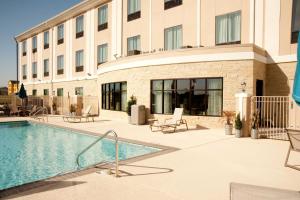 uma piscina num hotel com cadeiras e um edifício em Holiday Inn Express and Suites Schulenburg, an IHG Hotel em Schulenburg