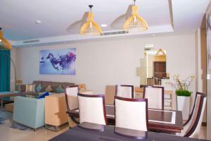 Gulf Executive Hotel & Residence Juffair في المنامة: غرفة معيشة مع طاولة وكراسي وأريكة