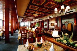 jadalnia ze stołami i krzesłami w restauracji w obiekcie Hotel Gasthof Markterwirt w mieście Altenmarkt im Pongau