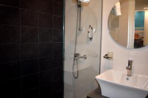 een badkamer met een douche en een wastafel bij Athenian Montaza Hotel in Athene