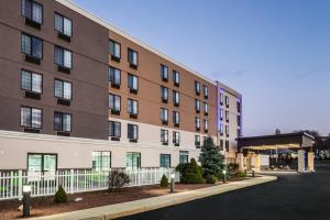 ein großes Gebäude mit einem weißen Zaun neben einer Straße in der Unterkunft Holiday Inn Express Hotel & Suites Providence-Woonsocket, an IHG Hotel in Woonsocket