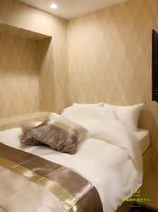 a bed with white sheets and pillows in a room at 西船橋駅前 HOTEL in Funabashi