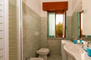 ミントゥルノにあるCapri Apartmentのバスルーム(トイレ、洗面台付)、窓が備わります。
