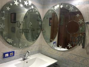 2 espejos sobre un lavabo en el baño en La casita de la dormilona, en Algimia de Almonacid