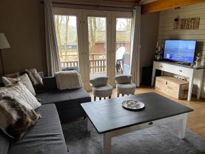 ein Wohnzimmer mit einem Sofa und einem Tisch in der Unterkunft Chalet234 in La Boverie in Rendeux