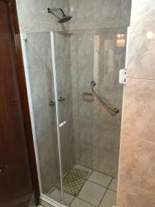 a shower with a glass door in a bathroom at Hotel Residencial Itapema in Itapema