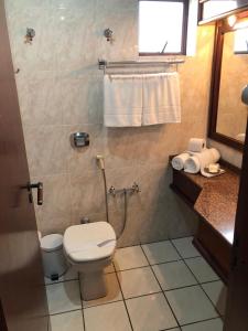La petite salle de bains est pourvue de toilettes et d'un lavabo. dans l'établissement Hotel Residencial Itapema, à Itapema