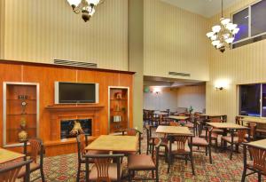 a restaurant with tables and chairs and a fireplace at Holiday Inn Express Hotel & Suites Ontario Airport-Mills Mall, an IHG Hotel in Rancho Cucamonga