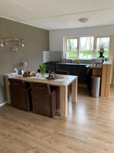 a kitchen with a table in the middle of a room at Skoallehus vakantiewoning in De Bult