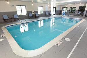 - une grande piscine d'eau bleue dans un bâtiment dans l'établissement Holiday Inn Express & Suites Omaha South Ralston Arena, an IHG Hotel, à Omaha