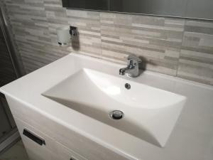 a white sink in a bathroom with a mirror at Carmine's holiday home in Torre Annunziata +11 photos