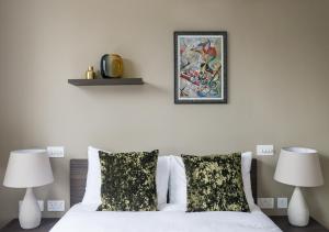 a bedroom with a white bed with two lamps at Mirabilis Apartments, Wells Court in London