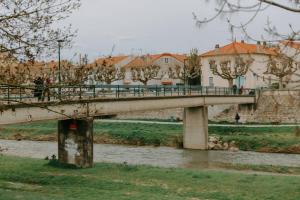 a bridge over a river with people walking on it at Les berges du Roubion studio cosy et moderne in Montélimar