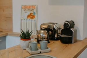 a kitchen counter with a coffee maker and cups on it at Les berges du Roubion studio cosy et moderne in Montélimar