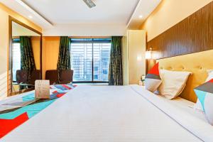 ein Hotelzimmer mit einem großen Bett und einem Fenster in der Unterkunft FabExpress Step Inn in Kalkutta
