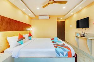 a bedroom with a bed and a flat screen tv at FabExpress Step Inn in Kolkata