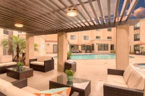 een patio met een zwembad en tuinmeubilair bij Holiday Inn Express Hotel & Suites Carlsbad Beach, an IHG Hotel in Carlsbad