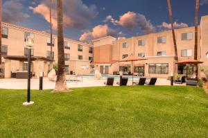 ein Gebäude mit einem Innenhof mit Stühlen und Sonnenschirmen in der Unterkunft Holiday Inn Express Hotel & Suites Carlsbad Beach, an IHG Hotel in Carlsbad