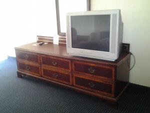 TV en la parte superior de una cómoda de madera en Budget Inn, en Tulare