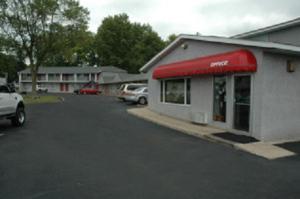 un magasin avec un auvent rouge dans un parking dans l'établissement Lakeview Inn, à Willmar
