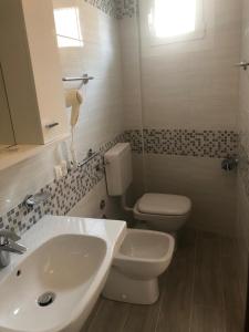 ein Badezimmer mit einem weißen Waschbecken und einem WC in der Unterkunft Hotel American in Lido di Jesolo