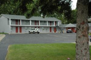 a large white building with red doors and a parking lot at Lakeview Inn in Willmar
