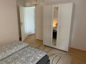 een slaapkamer met een bed en een dressoir met een spiegel bij Ferienwohnung Stella in Ichenhausen