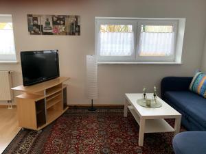 a living room with a tv and a couch and a table at Ferienwohnung Stella in Ichenhausen