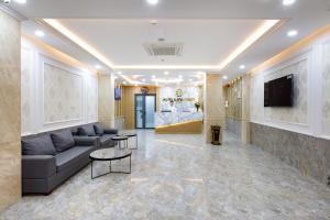 a living room with a couch and a tv at XO Hotel & Apartments in Nha Trang