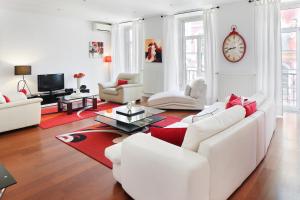 uma sala de estar com mobiliário branco e um tapete vermelho em Lisbon Rentals Chiado em Lisboa