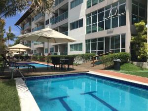 a swimming pool in front of a building at Porto Plaza Flat - 404 in Porto De Galinhas