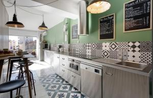 a kitchen with green walls and a counter with a sink at CANNES Festival Films Center, with 2 bedrooms and balcony in Cannes