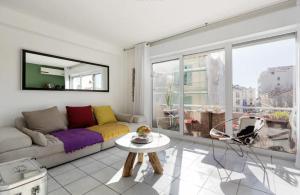a living room with a couch and a table at CANNES Festival Films Center, with 2 bedrooms and balcony in Cannes