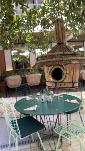 a table and chairs and a bird house in a restaurant at Centr'Hotel in Marigot