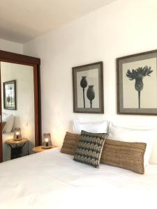 a bedroom with a white bed with three pictures on the wall at Centr'Hotel in Marigot +37 photos