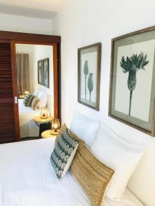 a bedroom with a white bed with two pictures on the wall at Centr'Hotel in Marigot