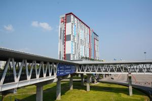 ein hohes Gebäude mit einer Brücke davor in der Unterkunft ibis Bangkok IMPACT in Nonthaburi