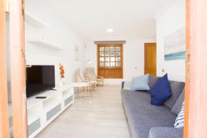 Una sala de estar con un sofá y un televisor. en Casa Betancuria, en San Bartolomé