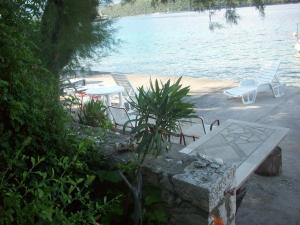 a picnic table and chairs next to the water at Apartments Tomović in Korčula