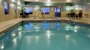 una piscina en un hotel con mesa y sillas en Holiday Inn Express & Suites Sioux Center, an IHG Hotel, en Sioux Center