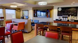 un restaurante con mesas y sillas y un bar en Holiday Inn Express & Suites Sioux Center, an IHG Hotel, en Sioux Center